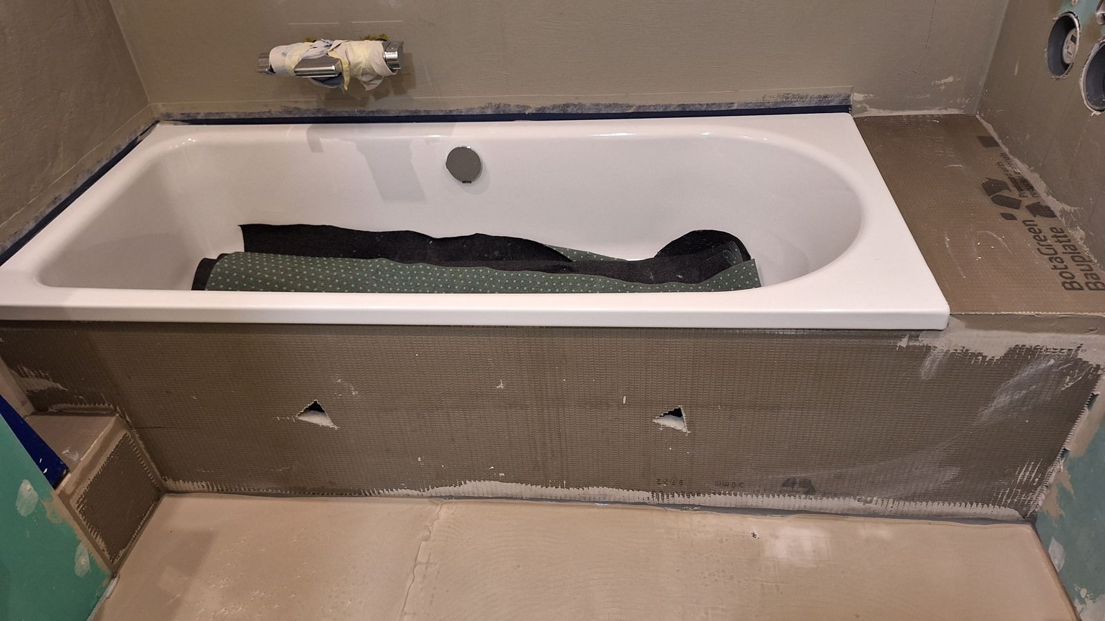Eingehauste Badewanne mit Dichtband am Rand, kurz vor dem Fliesen